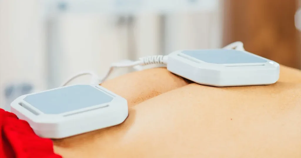 Magnetoterapia a domicilio in Lombardia: applicazione di solenoidi professionali sulla schiena di un paziente per stimolare la rigenerazione tissutale e ridurre il dolore direttamente a casa.