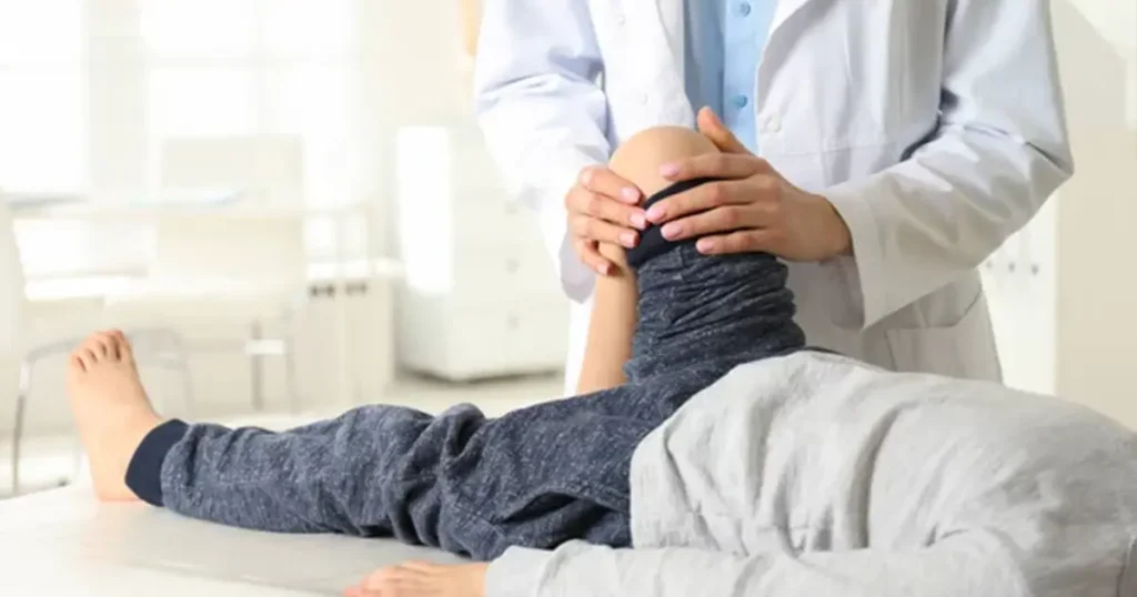 Visita ortopedica a domicilio in Lombardia: un medico specialista ortopedico esegue test di mobilità e valutazione clinica del ginocchio su un paziente a casa.