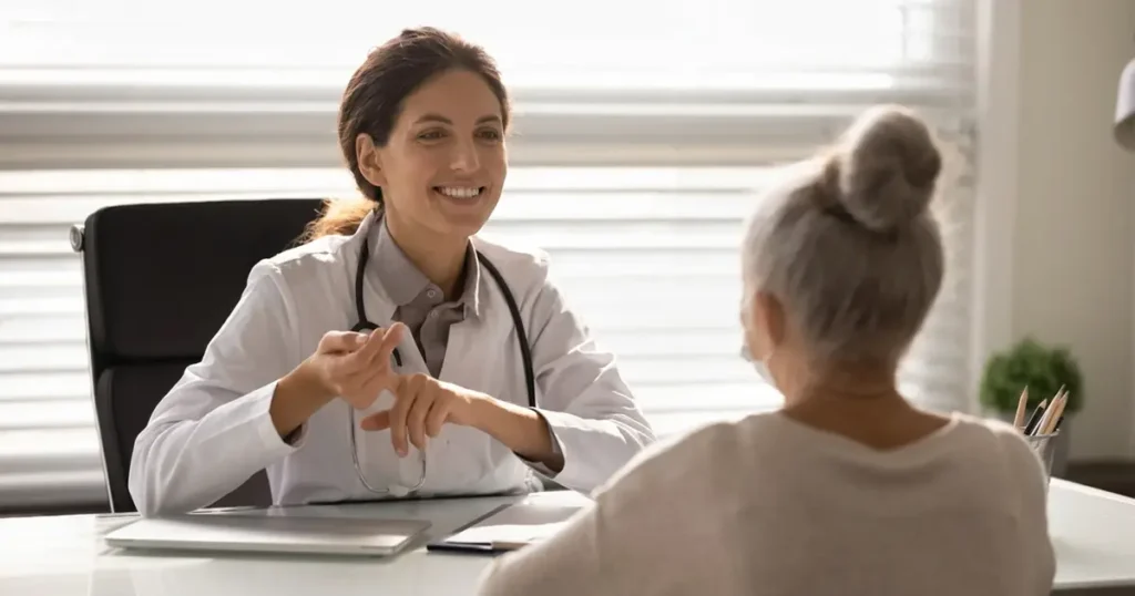 Visita geriatrica a domicilio in Lombardia: una dottoressa specializzata fornisce un consulto medico empatico e sicuro a una paziente anziana nella comodità della sua casa.